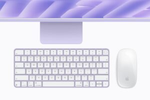 Color-matched Magic Keyboard and Magic Mouse below a purple iMac with M6