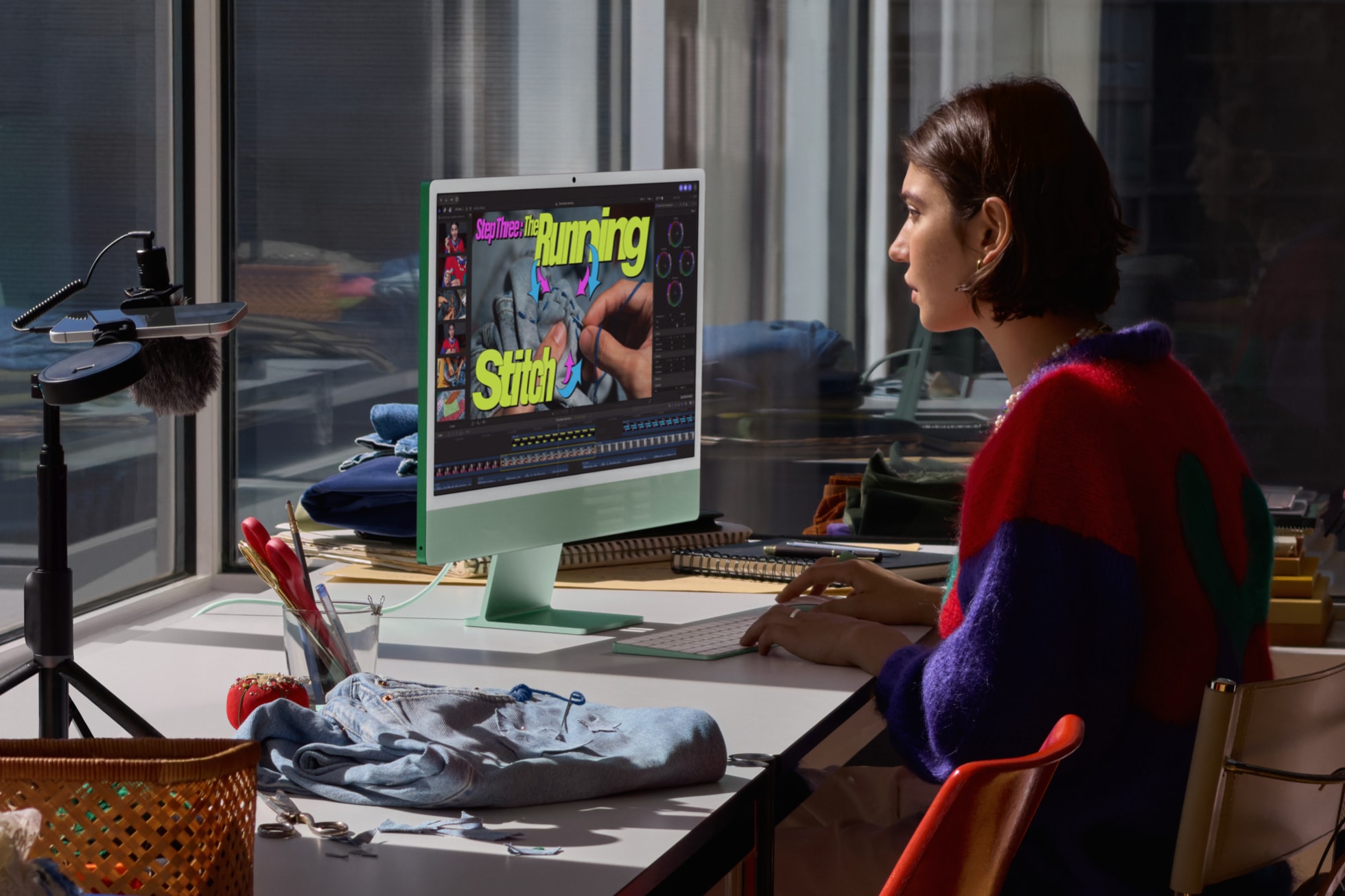 Green iMac with M6 on a desk while someone edits video