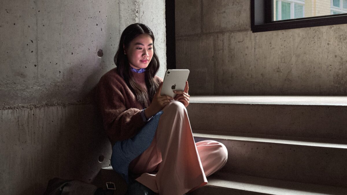 iPad Mini Costs $699, or $14.99 a Month Through Apple Upgrade 3 A person sitting on stairs holding the new iPad mini